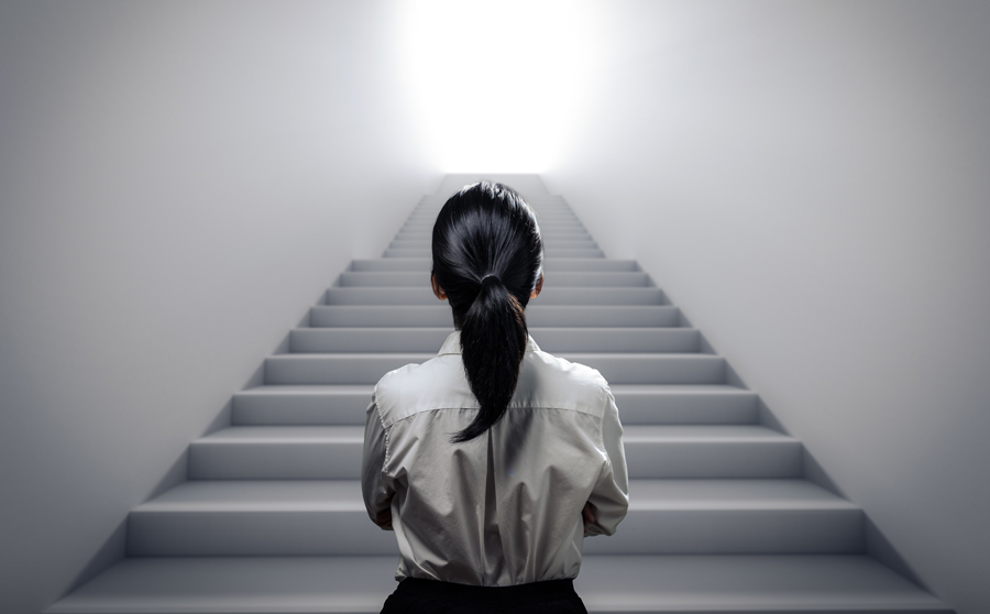 woman standing at the bottom of staircase looking up at the destination