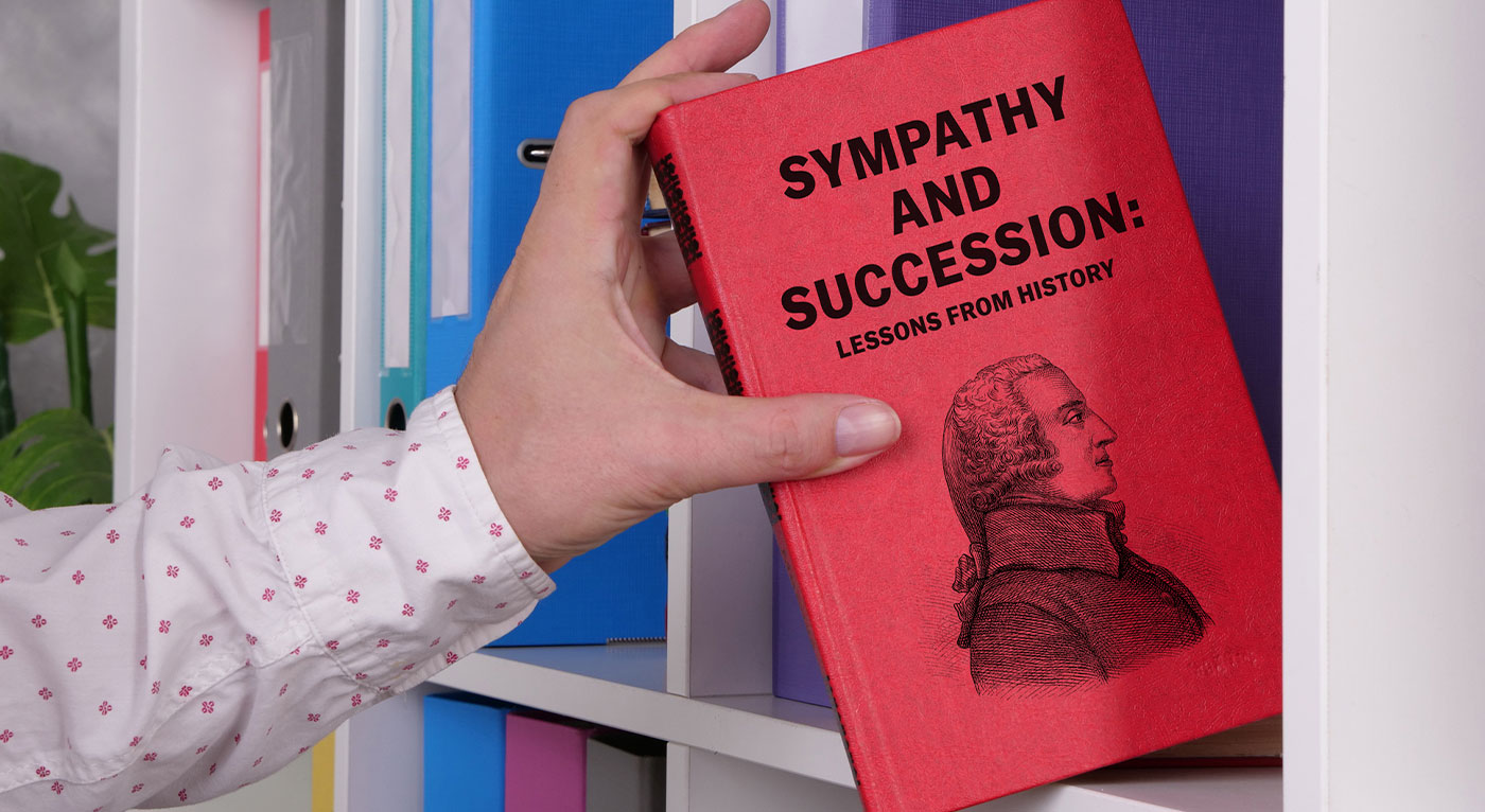hand grabbing red book with adam smith on it from shelf