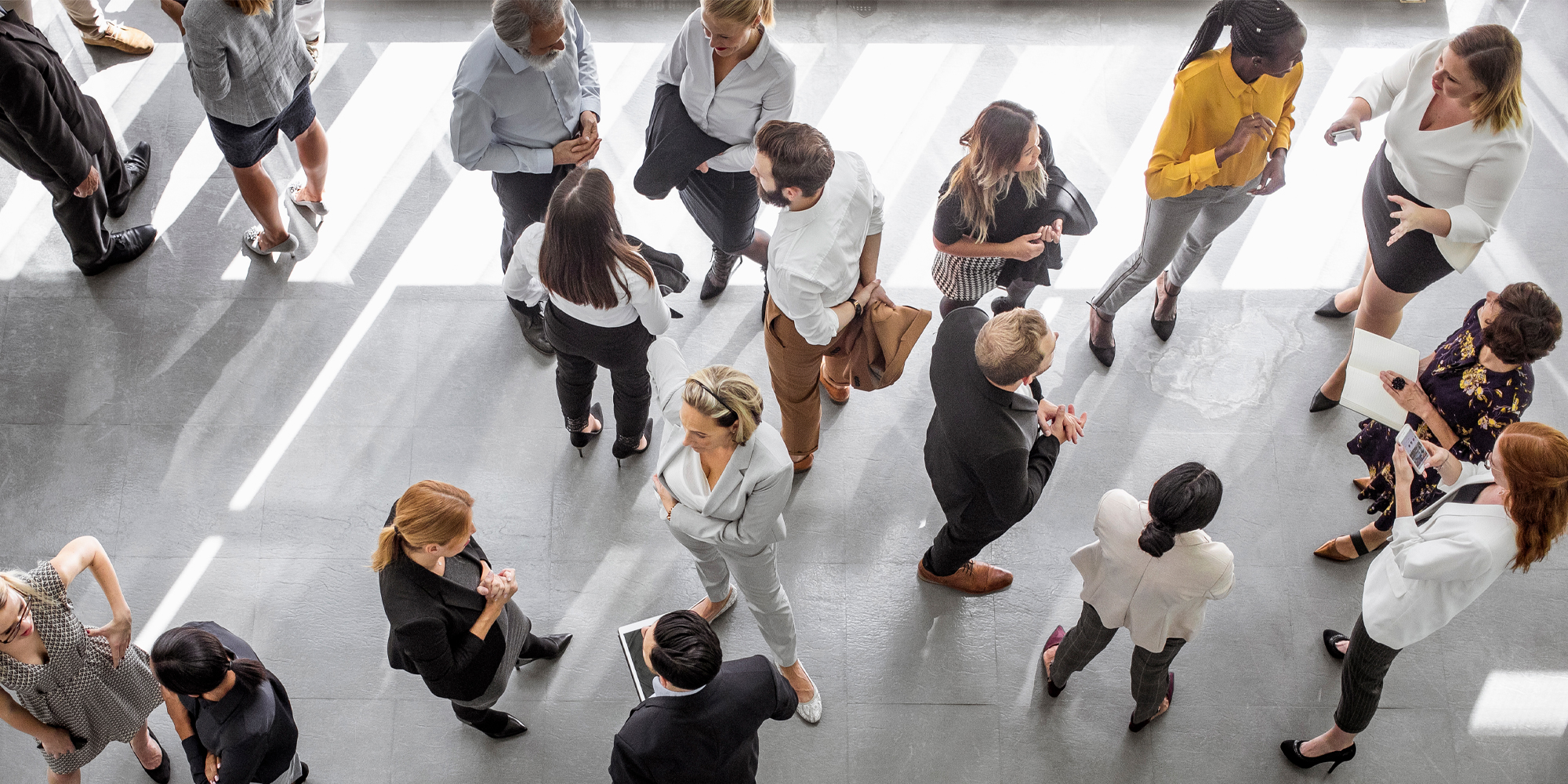 business associates all engrossed in mini meetings, wearing shades of mostly neutral colors
