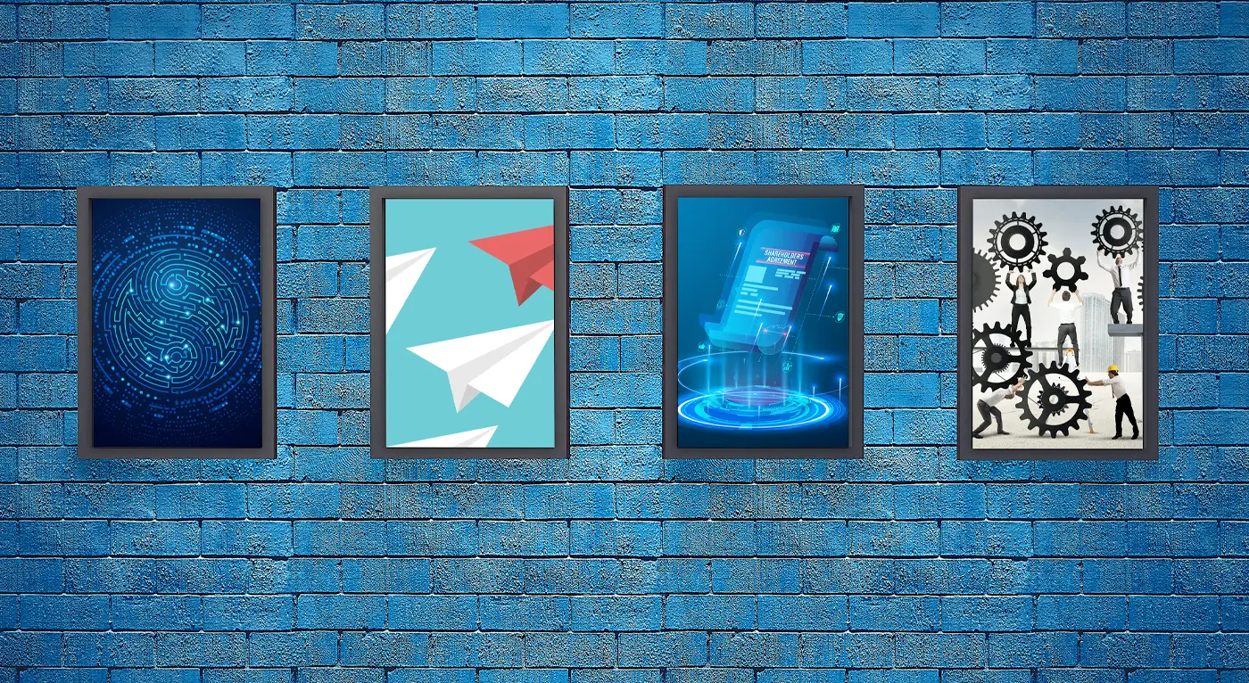 four framed posters on a blue brick wall