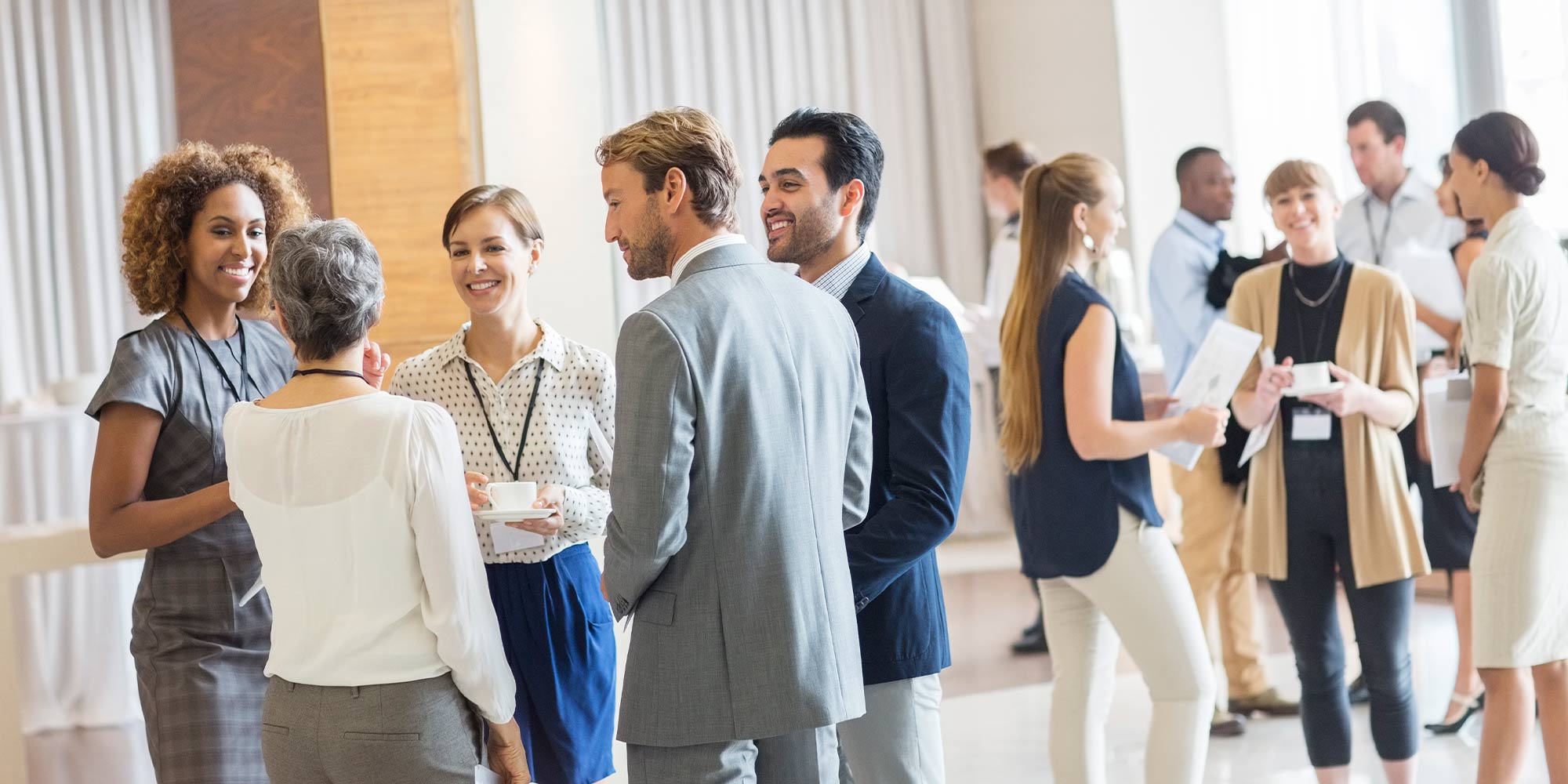 groups of people wearing business clothing mingling with one another