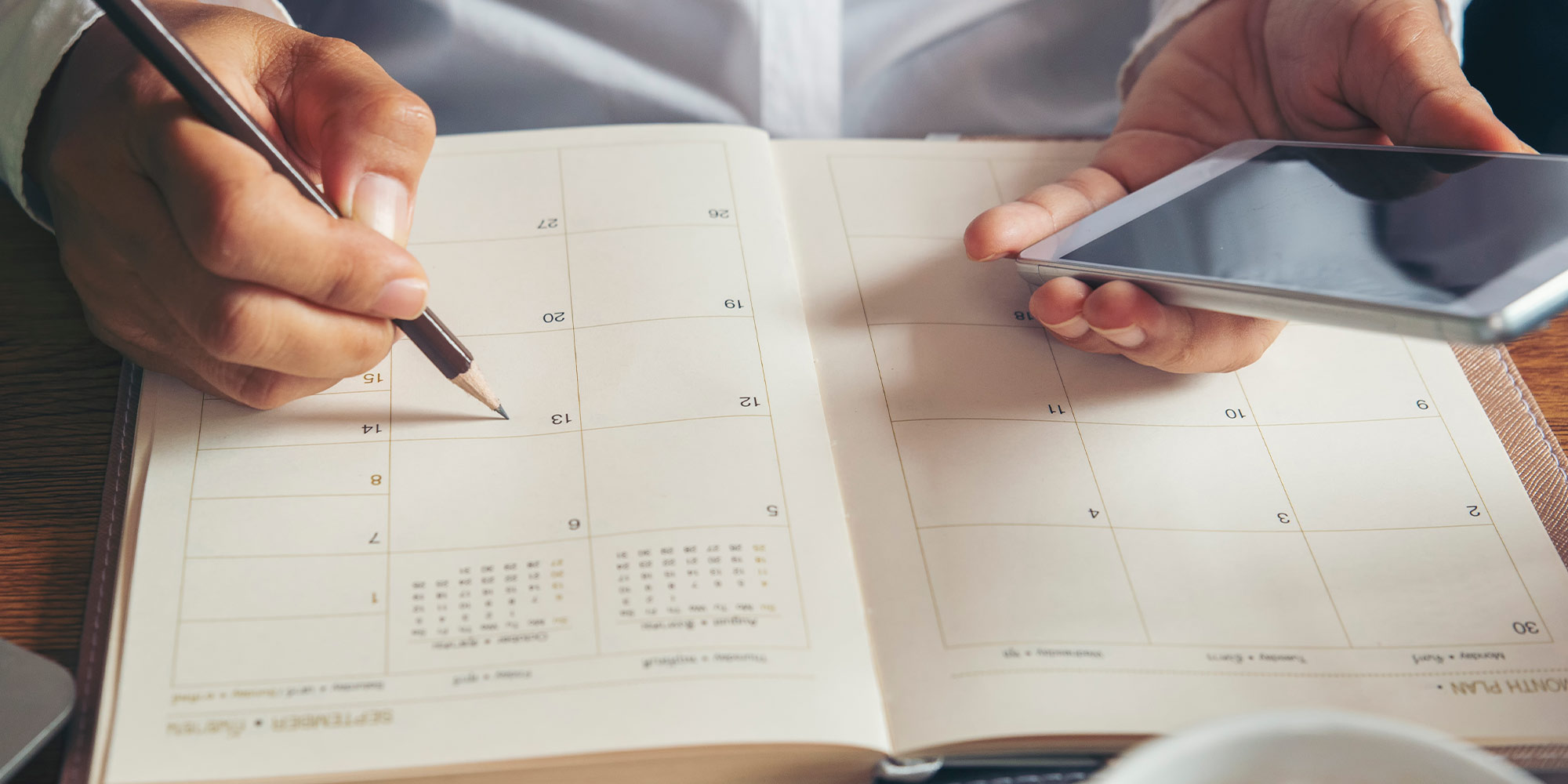 closeup of person marking a calendar in their agenda