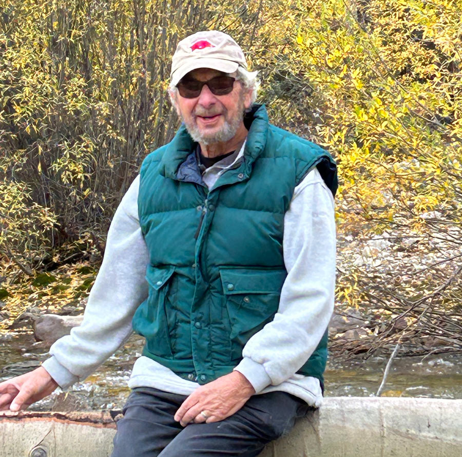 Henry Krasnow sitting on a log outdoors