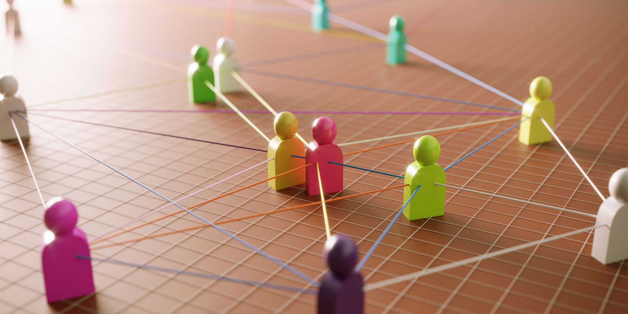 colorful wooden figures grouped together and tethered by strings