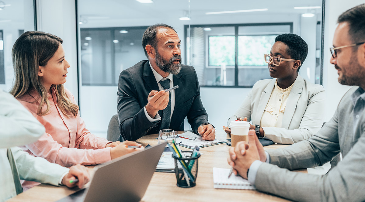 Modern business team discussing new ideas at the office. Business people on meeting in modern office. Colleagues smiling and talking at board room. Brainstorming