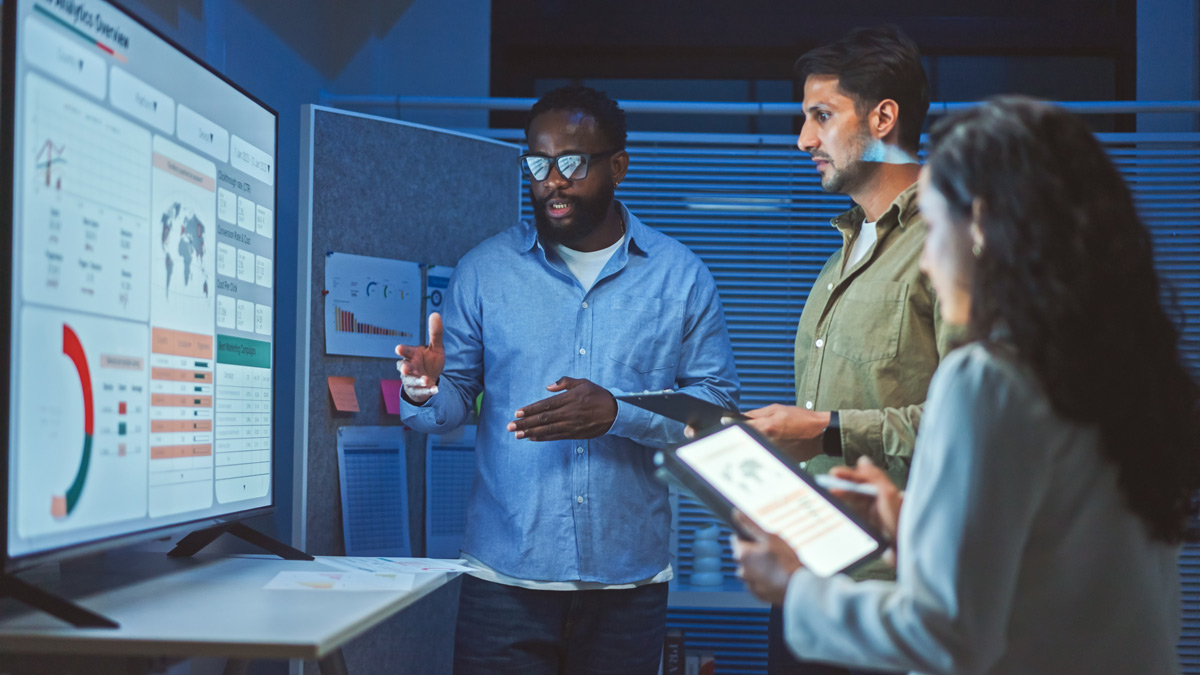 A team of multiethnic developers is meeting to review the data analysis of marketing from social media platforms.