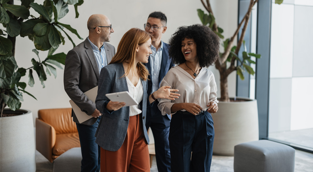 Colleagues share ideas and laughter in a casual setting, reflecting the importance of social interaction and positive relationships in the workplace.