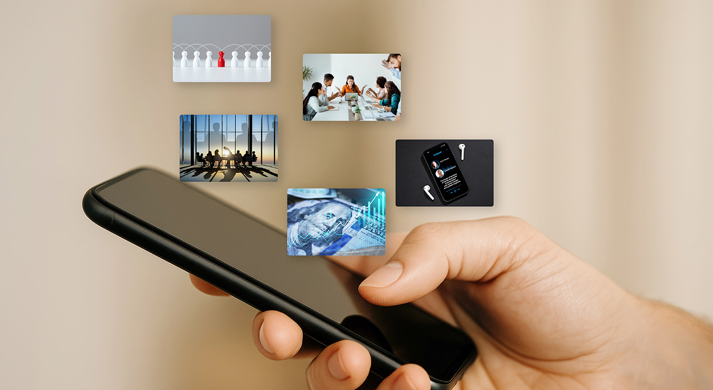 A smartphone held in a person's hand with various images floating above the screen, suggesting different app content.