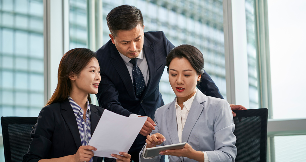 team of asian corporate executives discussing business in office