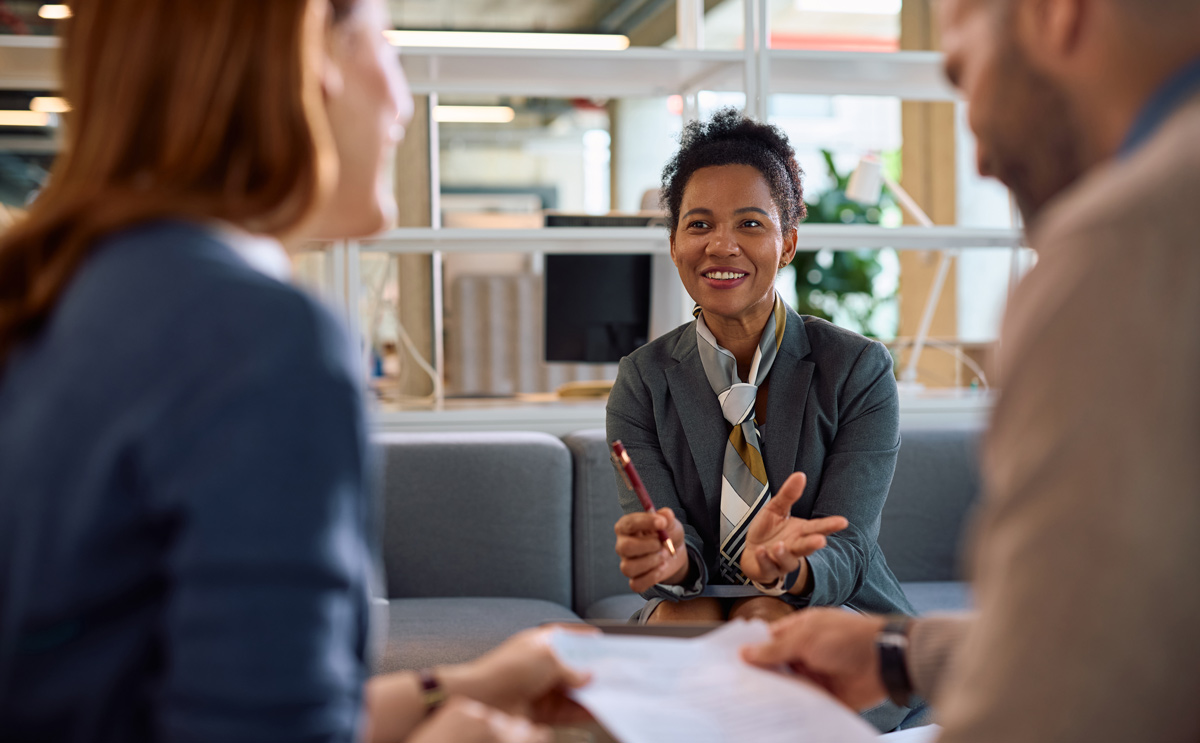 Happy financial consultant having a meeting with her clients in the office.